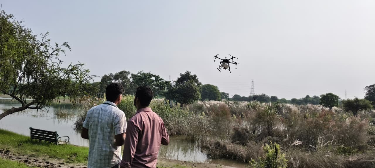 Aerocarrier spraying drone flying over flooded Yamuna River area during anti-larvicide project